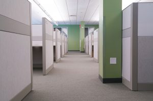 A modern office with rows of gray cubicles